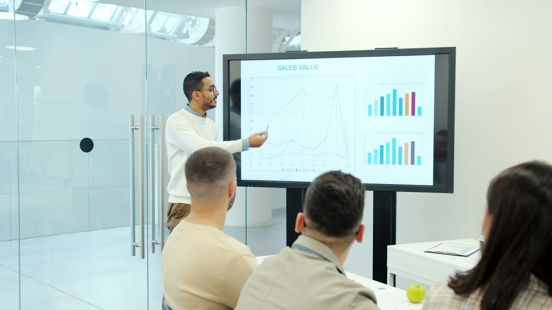 Man Presenting Charts on a Large Screen