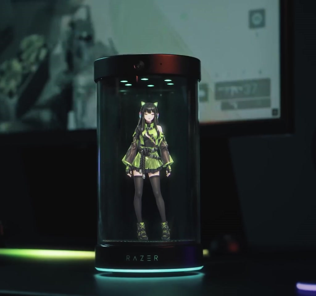 Vertical view of the Project Ava holographic projector casting a translucent humanoid avatar above a keyboard and mouse on a gaming desk