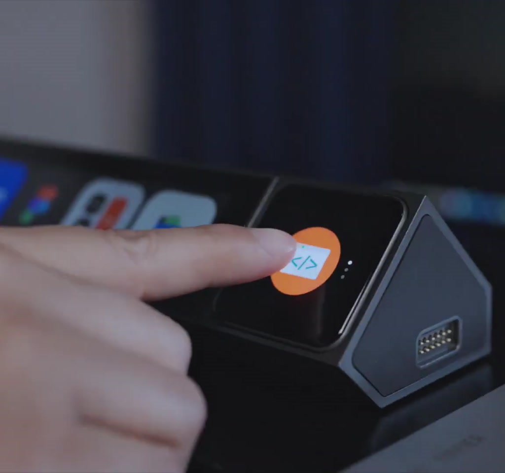 Vertical photo of a person holding a tablet displaying the UltraBar X interface overlaying a desktop screen with a warning icon near the grayed-out taskbar