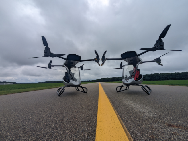 Velociter X-1 single-seat eVTOL lifting off from a suburban backyard, rotors spinning and pilot visible