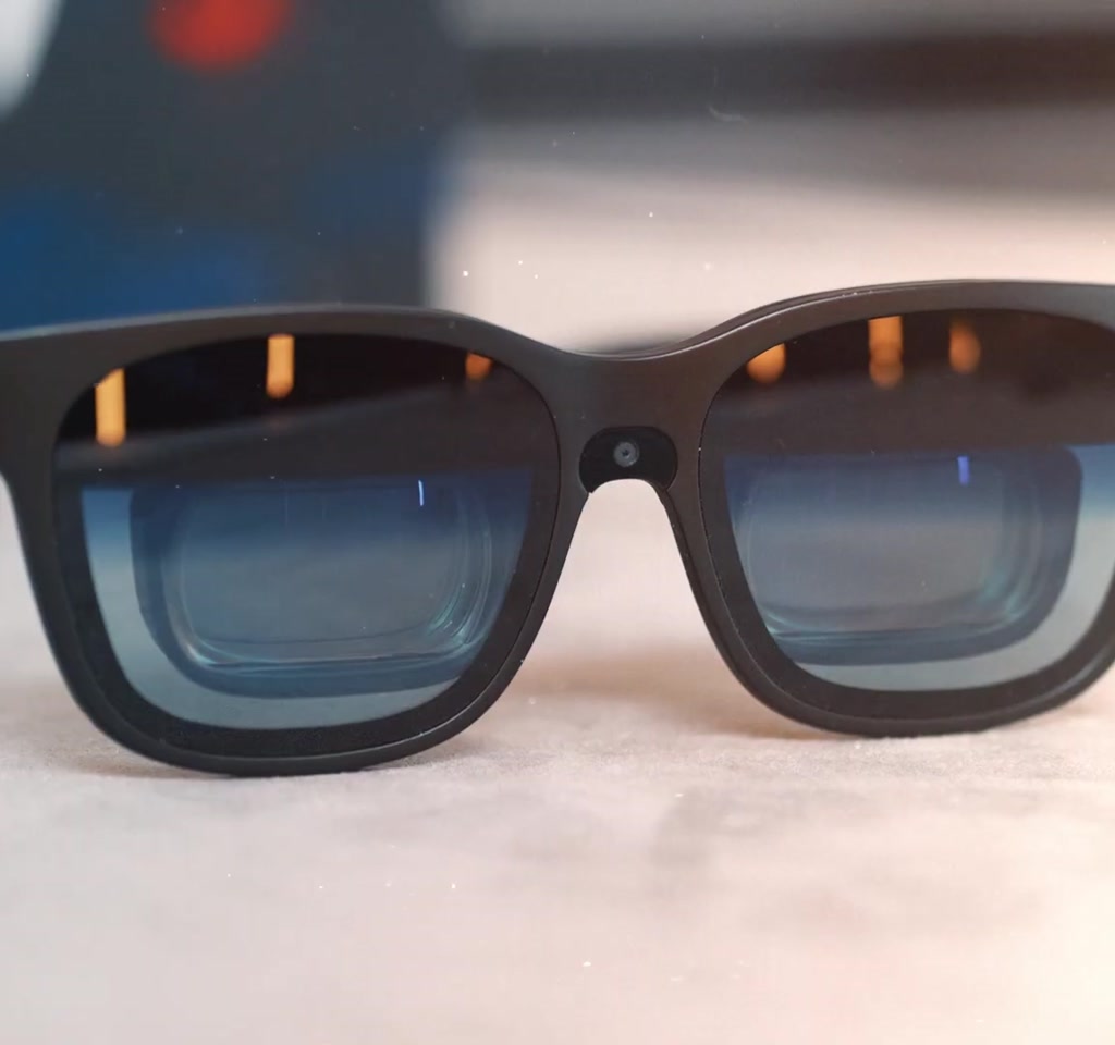 Traveler wearing Viture Beast XR glasses viewing a projected 174-inch virtual screen while seated with a carry-on bag and airplane window visible