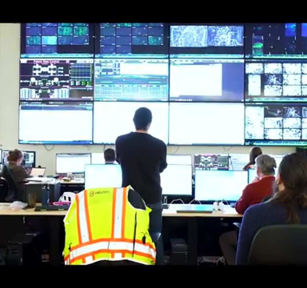 Vertical view of the Helion Polaris fusion chamber with a bright blue-white plasma jet from the first deuterium tritium shot