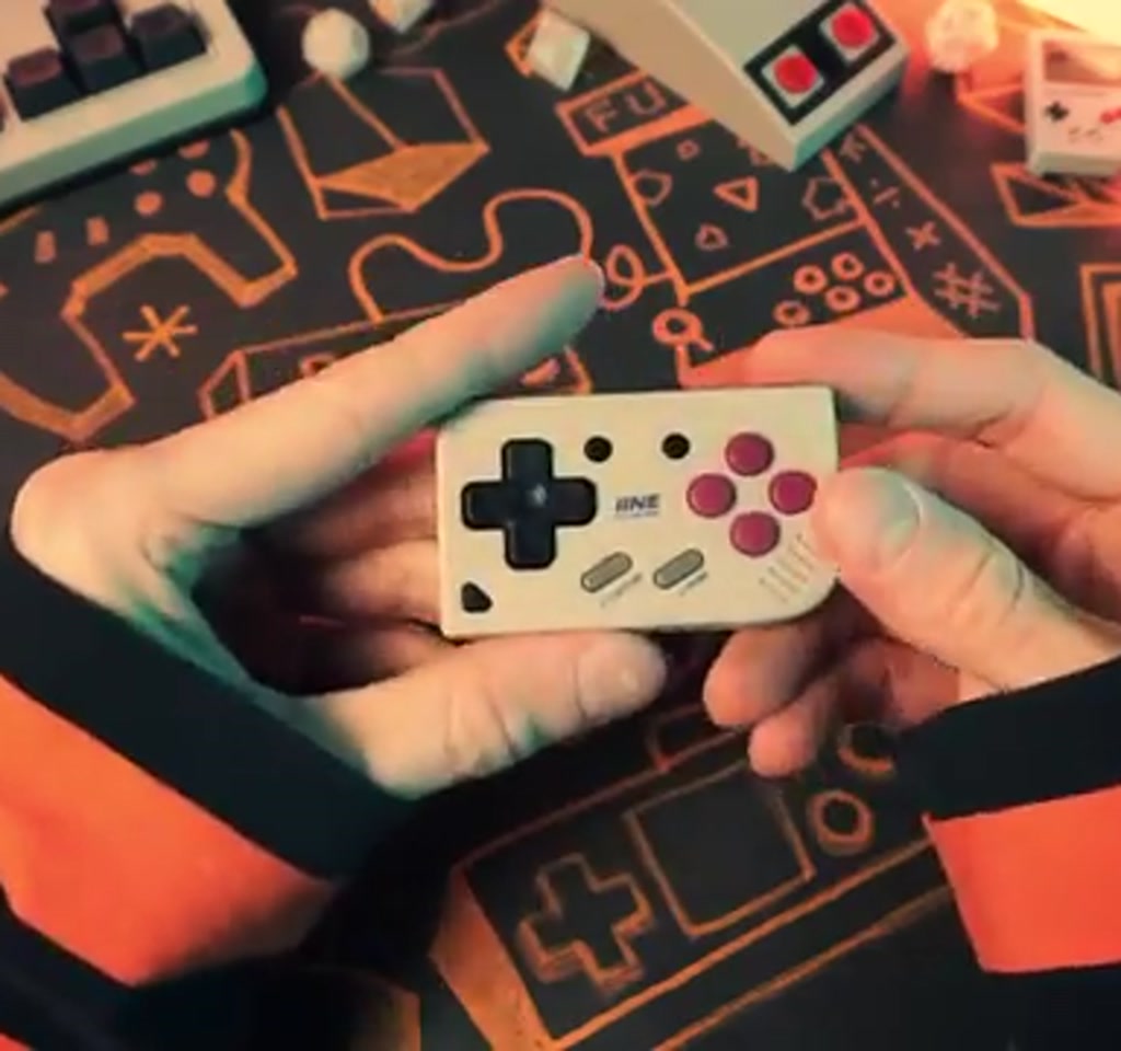 Transparent IINE Mini Switch controller held to show clear shell, buttons, analog stick, and compact size for portable gaming