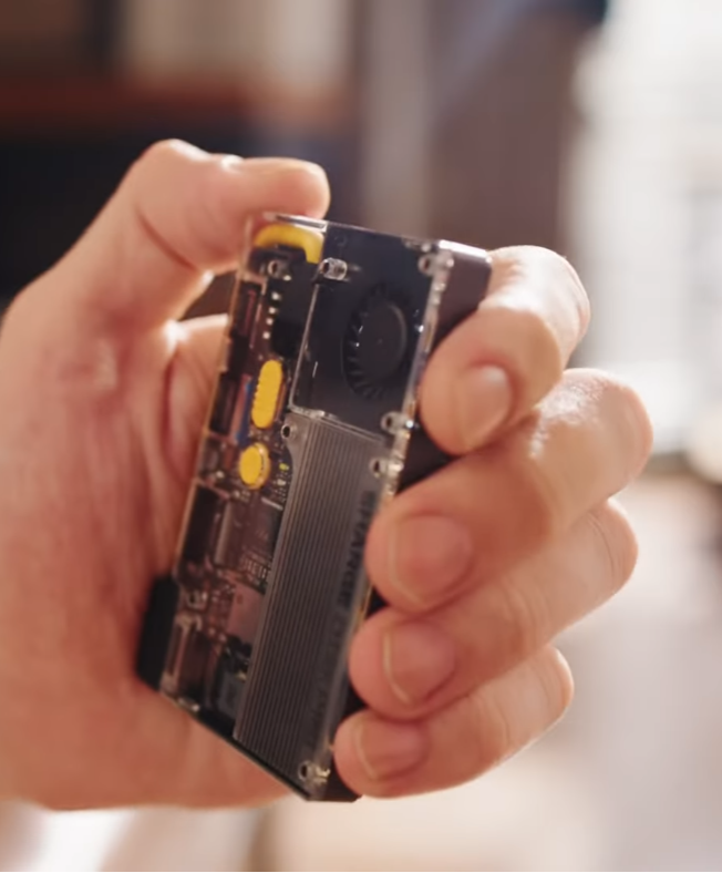 Vertical photo of the SHARGE Disk Pro pocket SSD hub mounted via MagSafe, showing cooling fins, USB-C ports and a compact mini dock